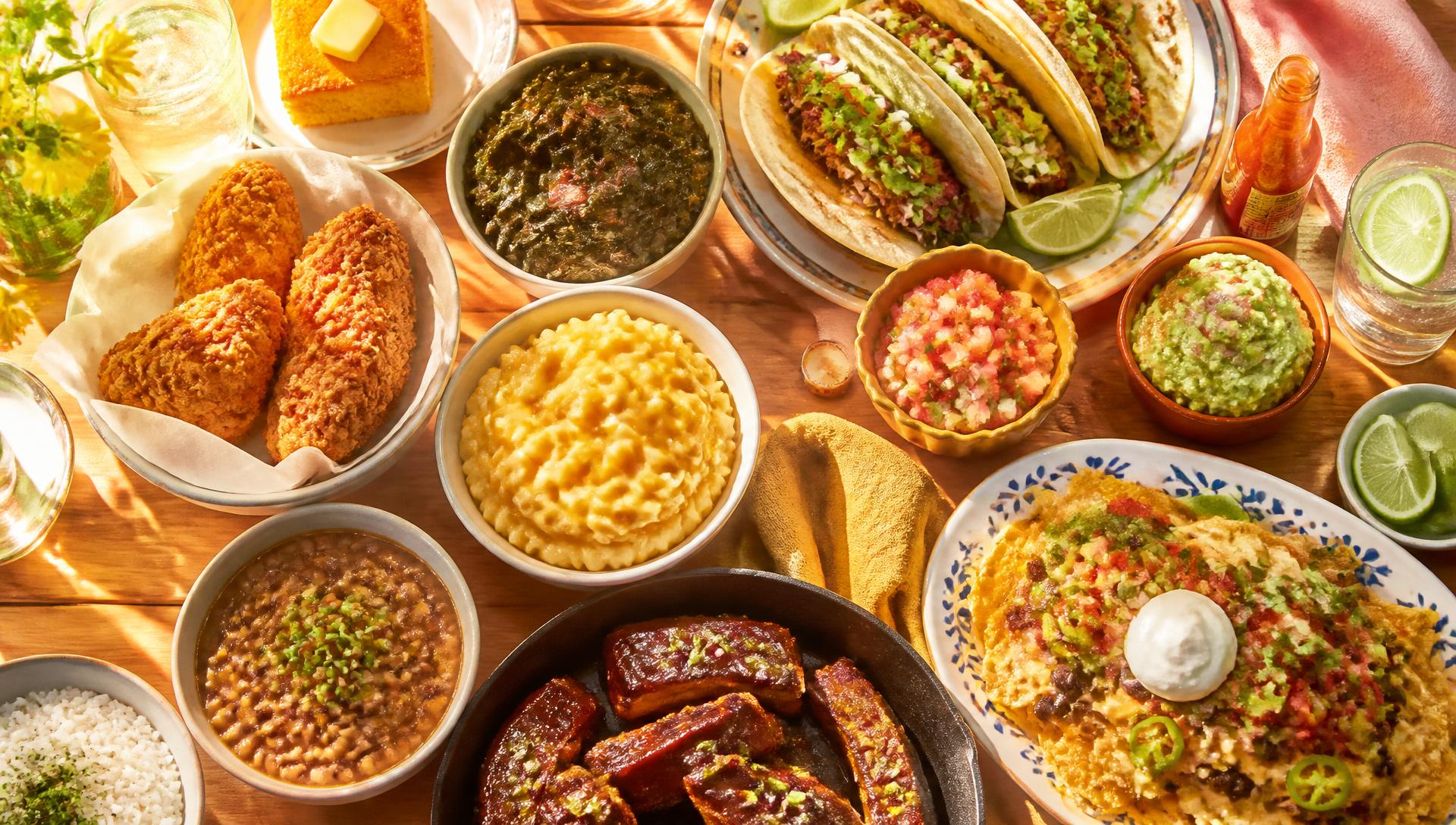 Spread of soul food, tacos and barbecue in bright sunlight